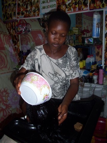 Une employée de Jolyderm en train de faire un shampoing (c) R. A. Dide