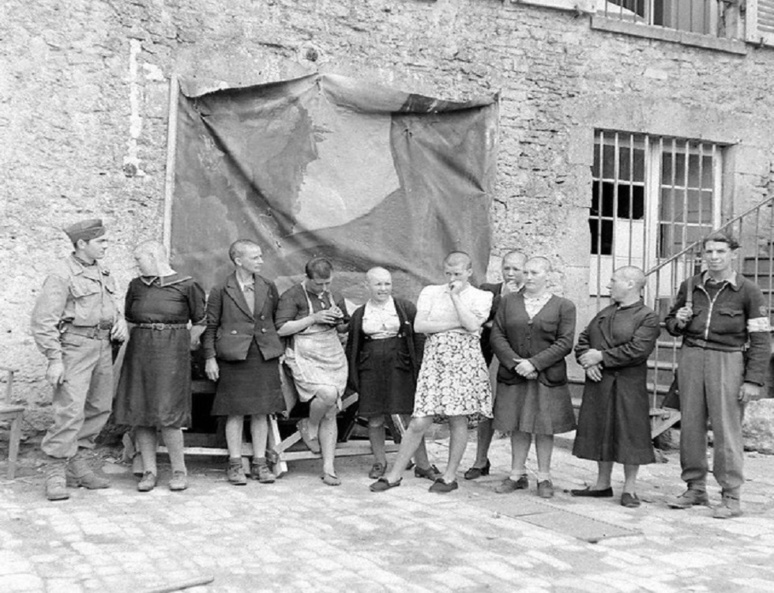 Un groupe de huit femmes tondues sous la surveillance de deux FFI. La scène se déroule au camp dépendant de Vichy, dans la Manche (c) Flickr