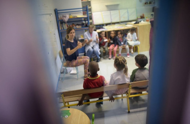 Une enseignante et une ATSEM accueillent une classe lors de la rentrée à l'école maternelle Merlin, en 2015. Lionel Bonaventure/AFP