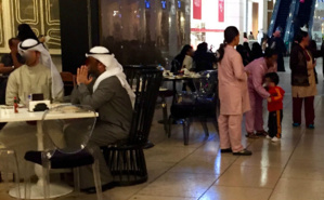 Trois travailleuses domestiques, repérables à leur uniforme, s'occupent de l'enfant dont les parents dînent au restaurant. Photo (c) Bulent Inan. Trois travailleuses domestiques, repérables à leur uniforme, s'occupent de l'enfant dont les parents dînent au restaurant. Photo (c) Bulent Inan.
