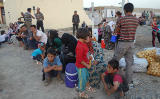 Des réfugiés kurdes syriens arrivés le 17 août 2015 au camp de Kawrgosk, près d'Erbil, attendent les camions de vivres. Photo (c) Béatrice Dillies