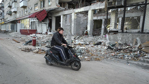 Un homme passe devant un immeuble près de Slavyansk, fortement endommagé lors des affrontements. Photo (c) UNHCR / Iva Zimova